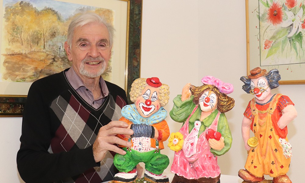 Künstler Sepp Fiedler mit den geschnitzten Clowns.