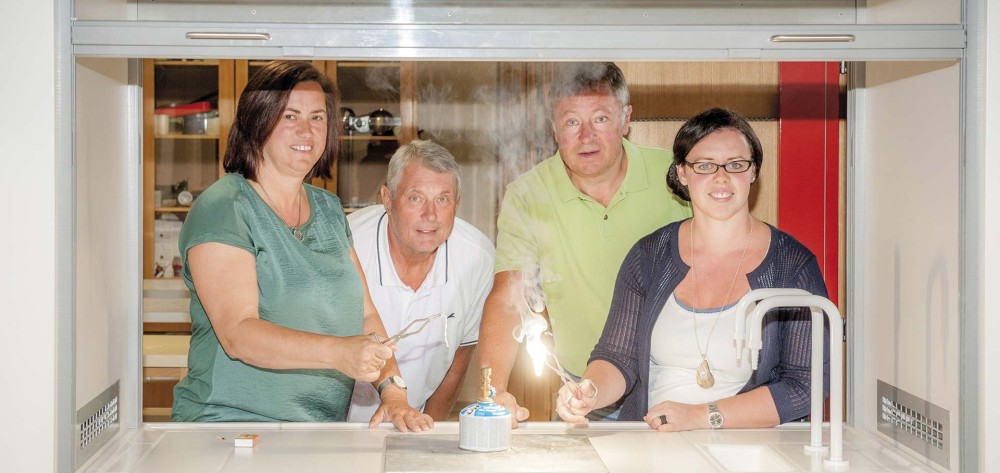 Der Durchlass mit Schutzglas im neuen Physiksaal: Kustodin Anita Feiertag, Direktor Wolfgang Welser, Bgm. Ing. Martin
                                    Falk, und Physiklehrerin Cornelia Ratteneder